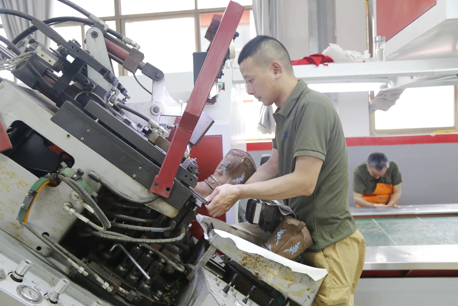Footwear craftsperson working on a shoe at SHI JI